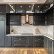 Taj Mahal Lux countertop and backsplash with dark kitchen cabinets and warm gold accents