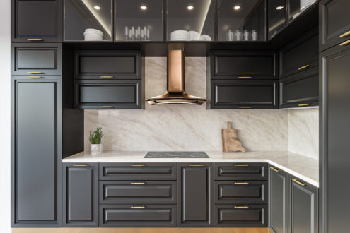 Taj Mahal Lux countertop and backsplash with dark kitchen cabinets and warm gold accents